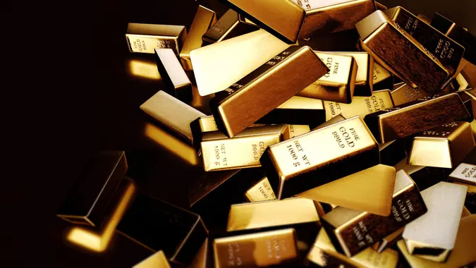 Gold bars fall on black background to showcase gold investing and strategy.