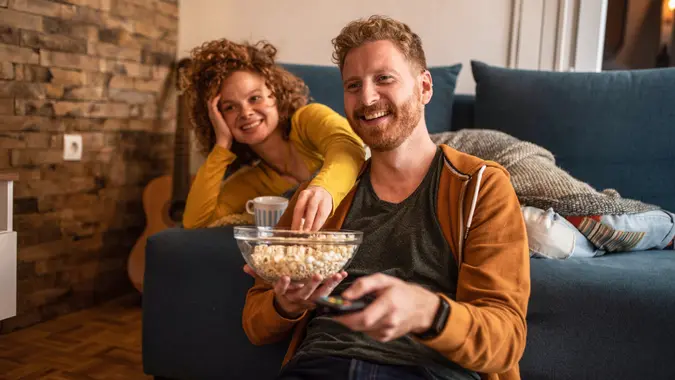 Young couple watching a movie at home. stock photo
