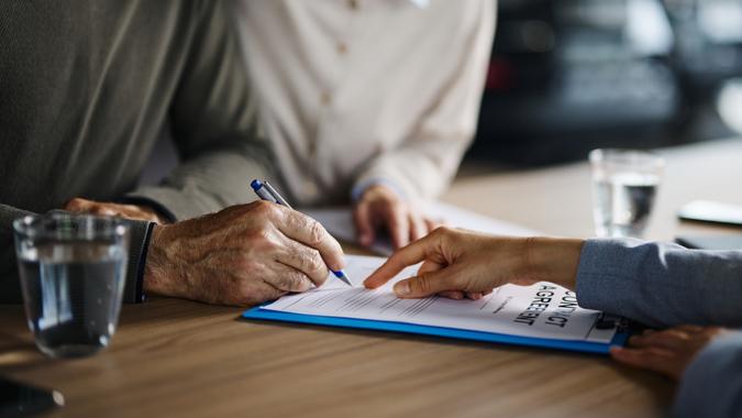 Close up of unrecognizable couple signing a contract. stock photo