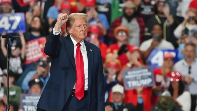 Former President Donald Trump raises a fist at the end of his rally.