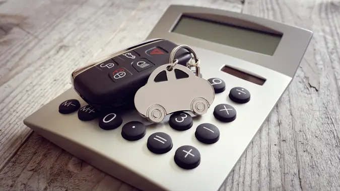 Car shape keyring and key on calculator stock photo