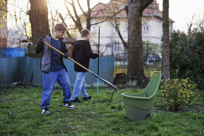Teenagers helping to clean the back yard after winter.