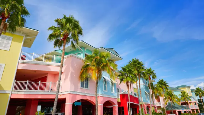 A block of colorful houses with palm trees in front on a sunny day in Fort Myers, Florida.