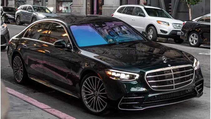 Mercedes Benz S Class driving down busy road for stock photo.