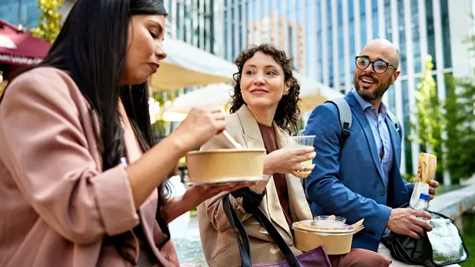 Office workers eating lunch together stock photo