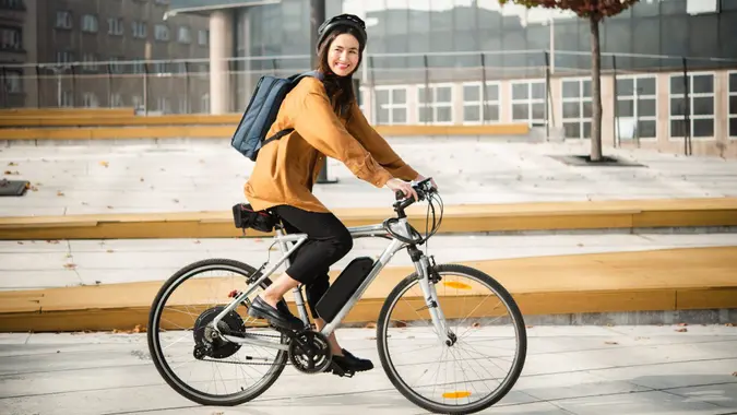 Asian businesswoman going to work on an electric bicycle.