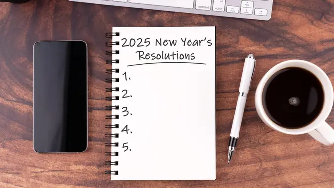 New Year's Resolutions 2025 text on note pad stock photo flat lay.