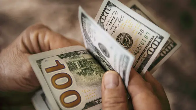 Unrecognizable mature man counting USA Dollar bills stock photo