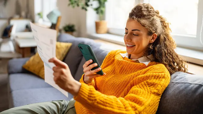 Woman using mobile phone to scan the QR code and paying the bill stock photo