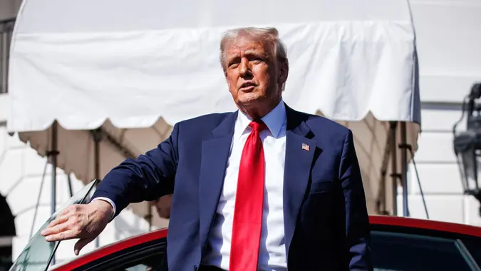 US President Donald Trump climbs out of a Tesla Model S on the South Lawn of the White House in Washington, D.