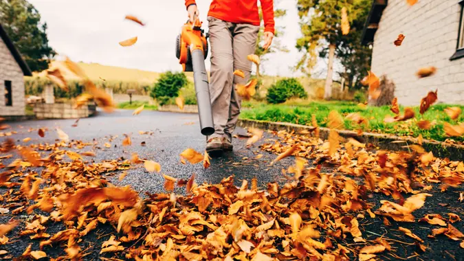 Leaf blower clearing driveway stock photo