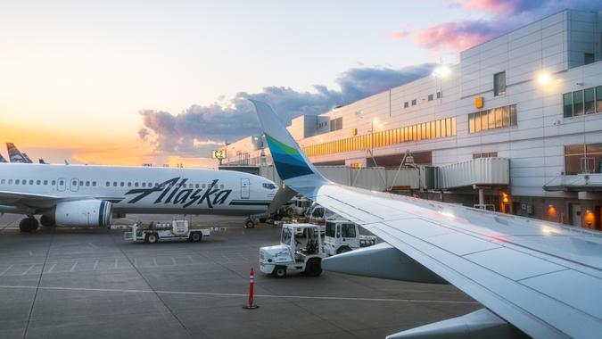 Anchorage, AK, USA - June 11, 2019- The sunsets on Ted Stevens Anchorage International Airport showing an Alaska Airlines plane in Anchorage Alaska.
