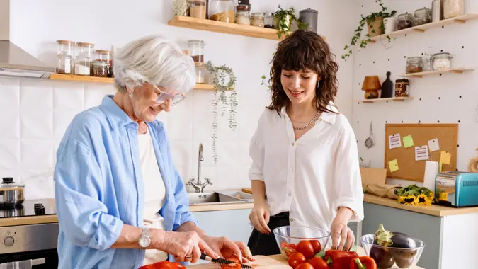Senior woman cooking with her granddaughter.