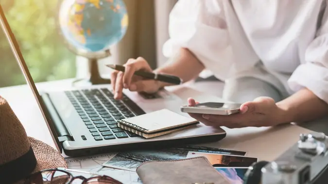 Young traveler planning vacation trip and searching information or booking hotel on laptop, Travel concept stock photo
