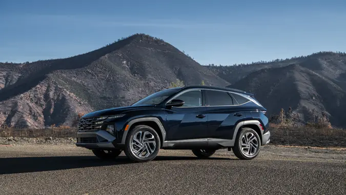 A Hyundai Tucson Hybrid with mountains behind it.