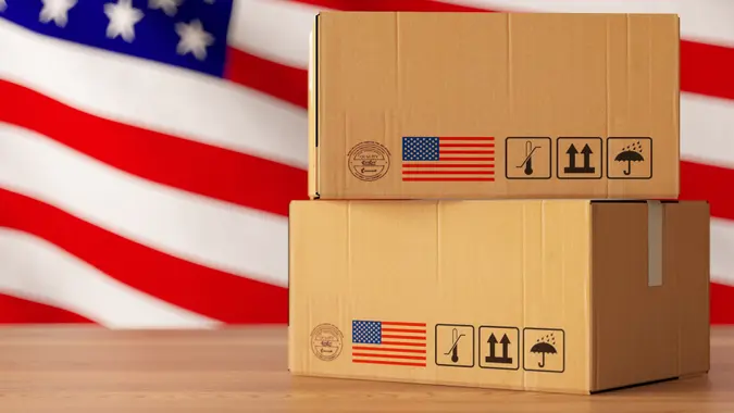Made in USA concept with cargo boxes stacked and an American Flag in the background.