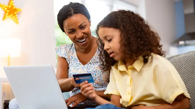 Mother and daughter of Black ethnicity online shopping from home stock photo