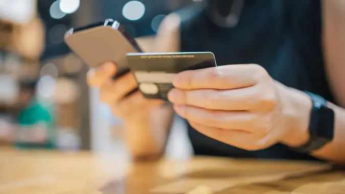GenZ paying debt and financial loan with her mobilephone and credit card