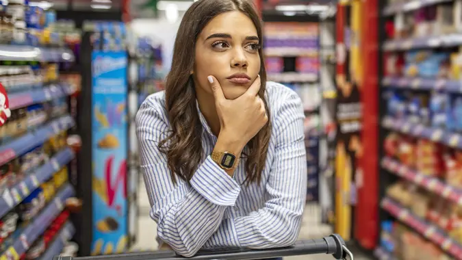 Woman buy products with her trolley at supermarket. stock photo