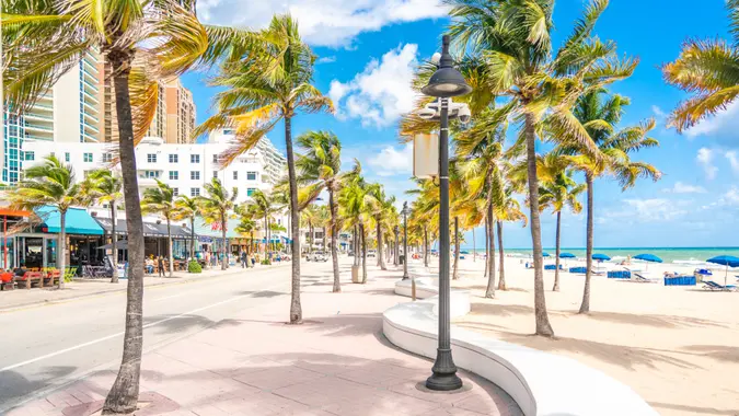 Seafront beach promenade with palm trees on sunny day in Fort Lauderdale.