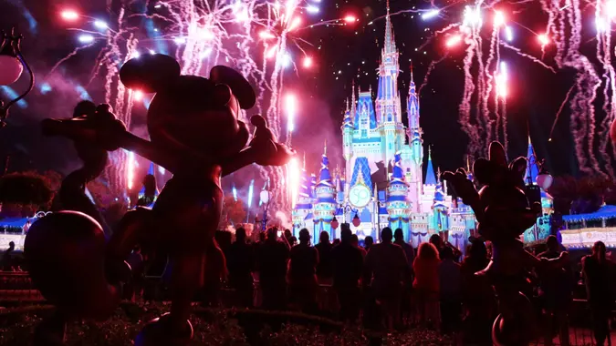 Golden sculptures of Disney Characters Mickey Mouse and Minnie Mouse, part of the Disney Fab 50 Character Collection, stand next to each other as the fireworks show titled "Enchantment" is displayed for the first time in Magic Kingdom Park during "The World's Most Magical Celebration" - the 50th anniversary of Walt Disney World Resort! on Thursday, September 30, 2021 in Orlando, Florida.