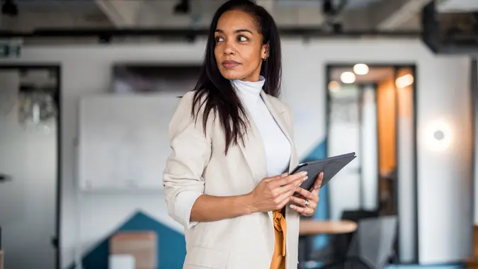 Confident Hispanic Businesswoman Analyzing Financial Markets stock photo
