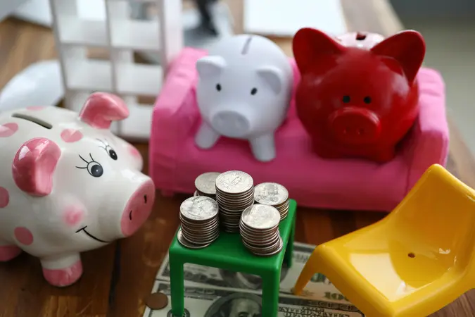 Group of three piggybanks trying to decide what to do with pile of money concept.