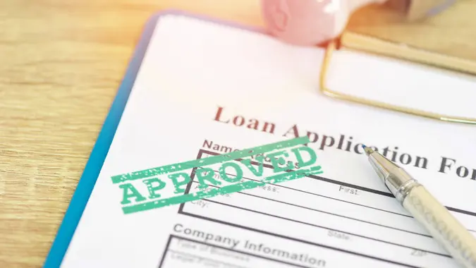Loan approval, Loan application form with Rubber stamping that says Loan Approved, Financial loan money contract agreement company credit or person.