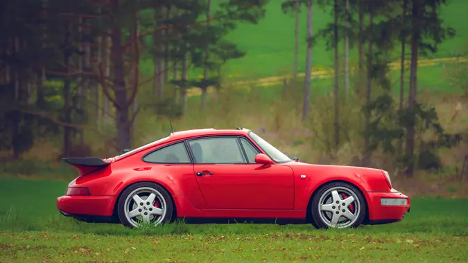 Münsingen, Germany - May 1, 2023: Porsche 911 930 Turbo Carrera german oldtimer vintage luxury sports car on a country road on a sunny summer day.