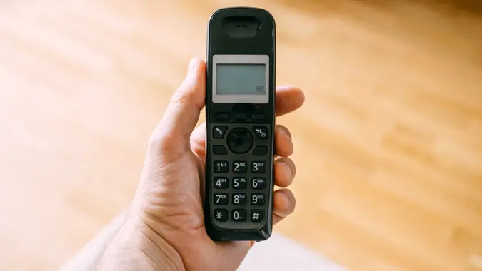 Male hand with cordless landline telephone device stock photo