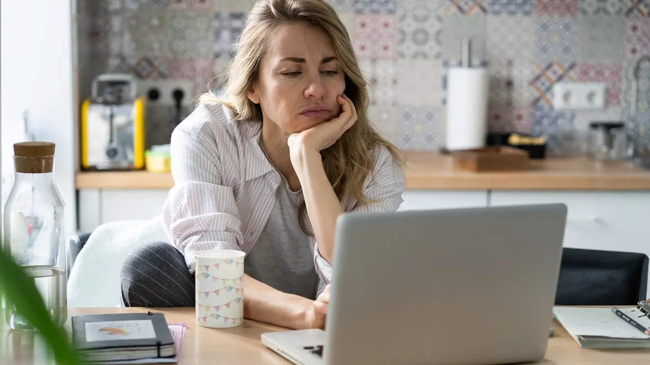 Displeased woman of middle age search for new job unemployed during covid-19 quarantine on laptop stock photo
