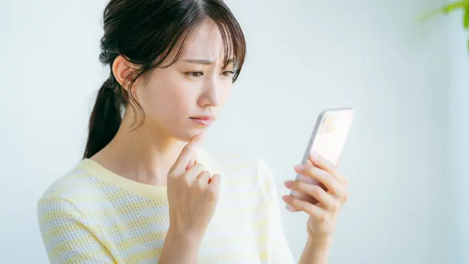 A woman operating a smartphone in the room stock photo