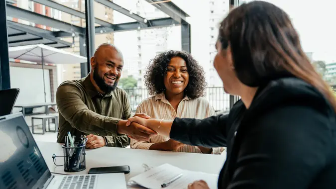 Black couple meets with bank teller or mortgage broker