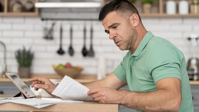 Men doing online learning on a digital tablet while staying at home. stock photo