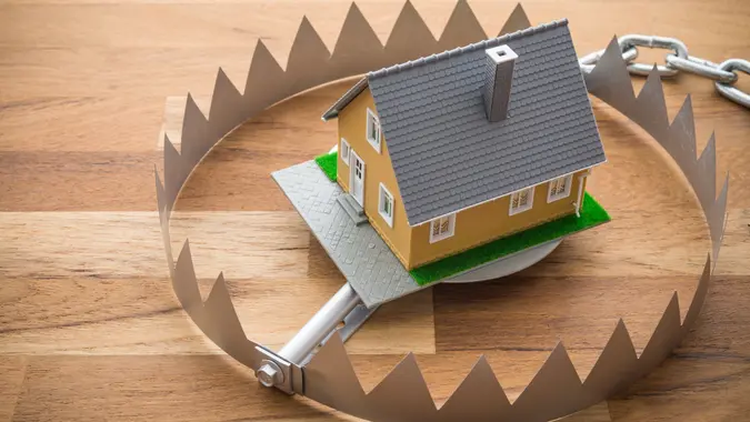 Mortgage house in a trap on wooden table background. stock photo