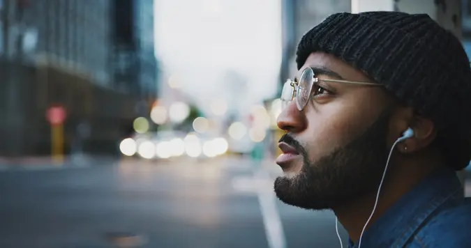 Shot of a young man listening to music in the city.