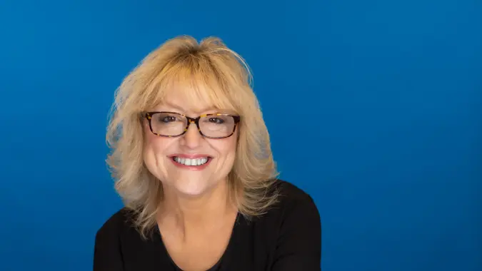 Shonette Holbrook smiling at the camera with a blue background