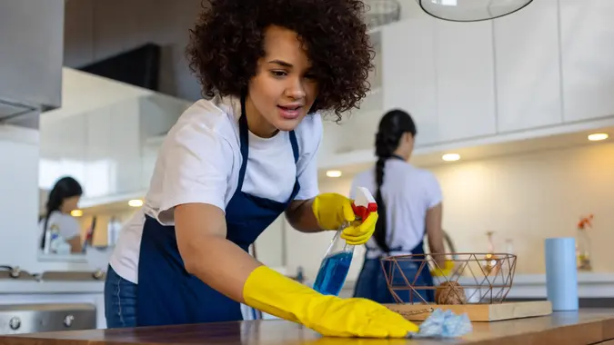 Professional cleaner cleaning a table at a house stock photo