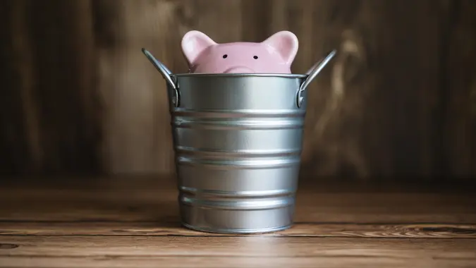 Piggy Bank Sinking Inside Steel Bucket stock photo