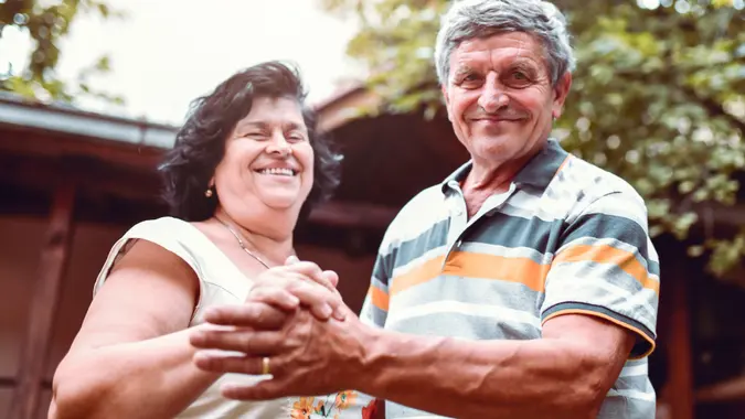 Happiness Expressed By Senior Husband And Wife Through Outdoor Dance In Backyard stock photo