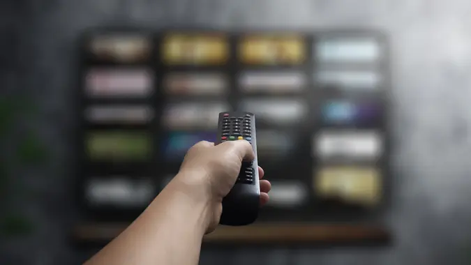 Concept - man with his remote control watching tv in his living room stock photo