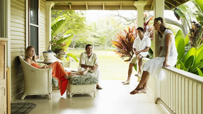 Group of friends sitting on front porch laughing stock photo