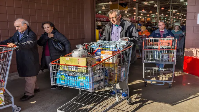 Fairfax, USA - December 3, 2016: People with shopping carts filled with groceries walking out of Costco store in Virginia.