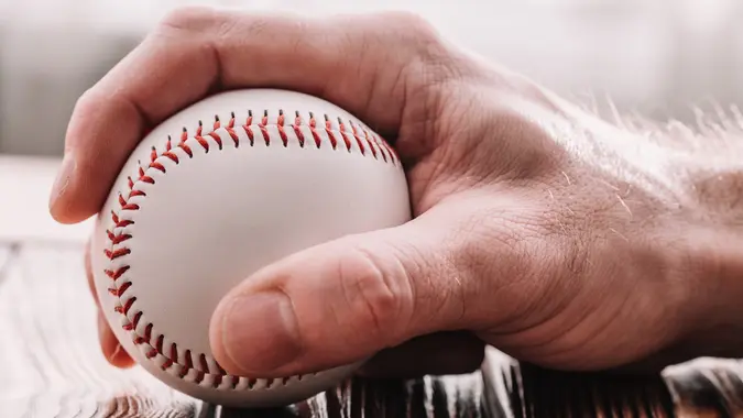 Male hand grabbing a baseball stock photo