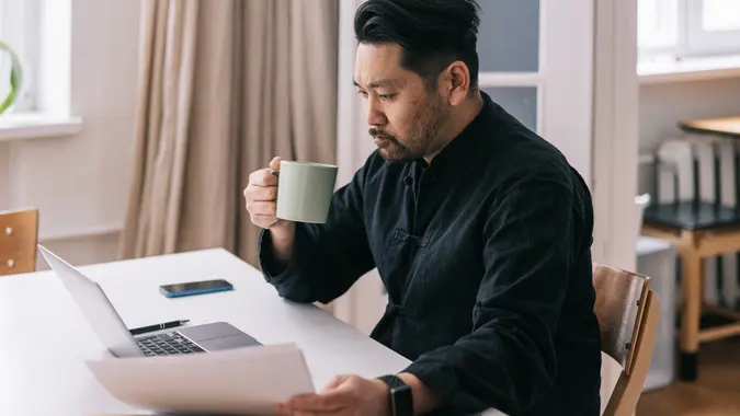 Japanese man sits at his desk, focused on managing his personal finances stock photo