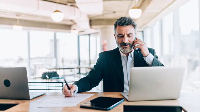 Businessman at the office talking on cell phone.