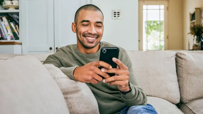 Shot of a young man using his smartphone to send text messages stock photo