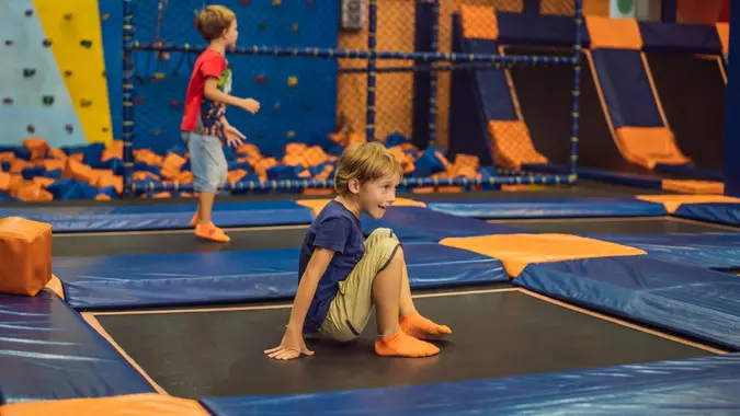 Cute boy jumping on trampoline in entertainment center stock photo