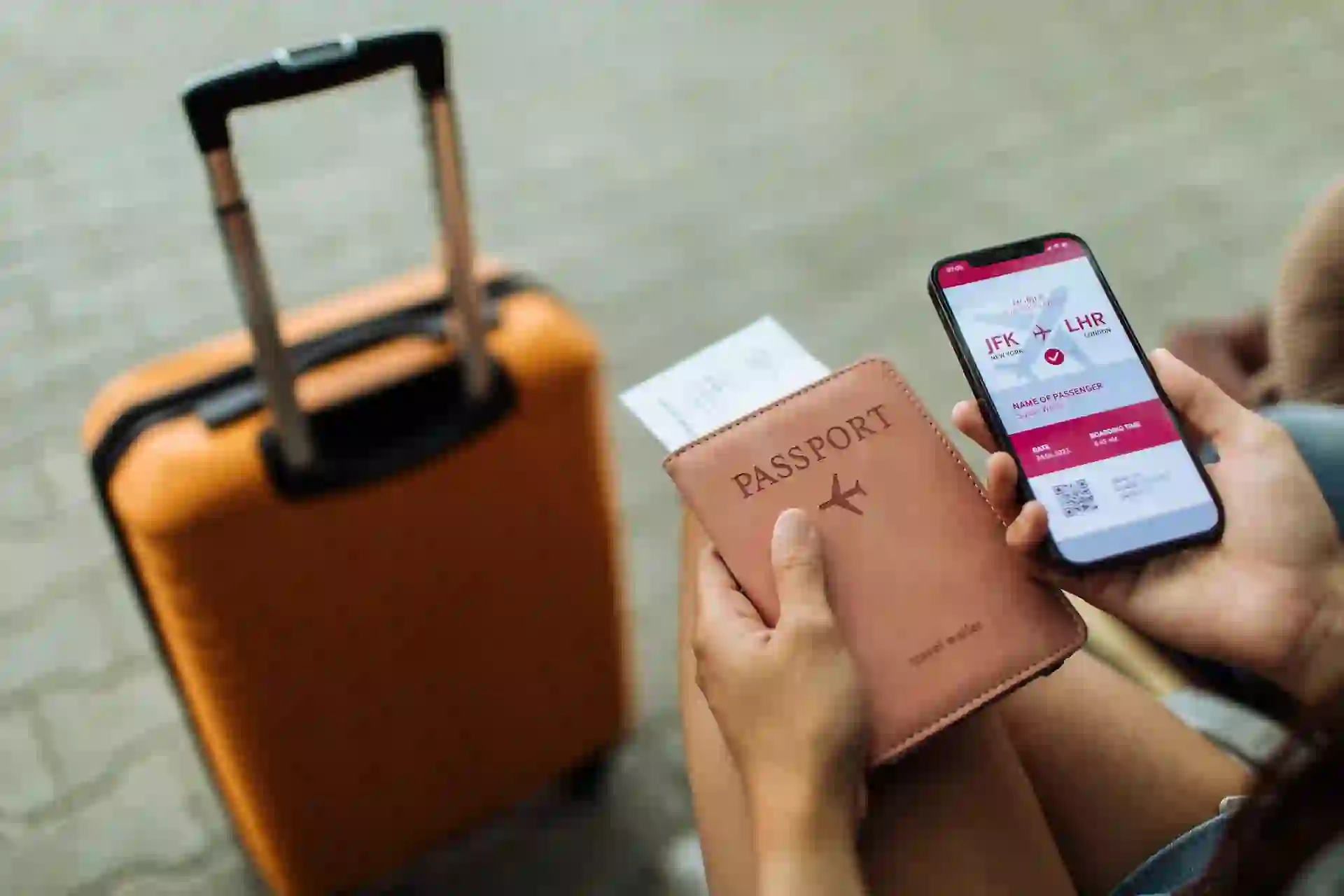 Young female is sitting at the airport holding a passport and a phone while waiting for a flight.
