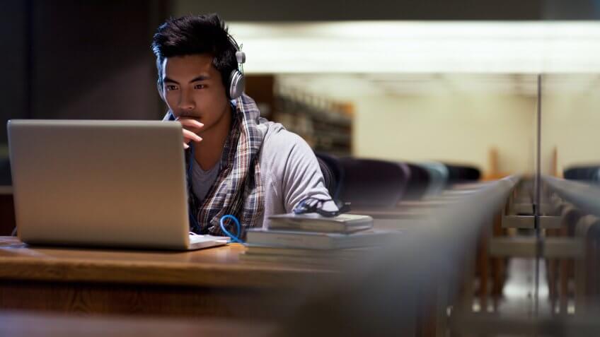Student working on laptop in library.